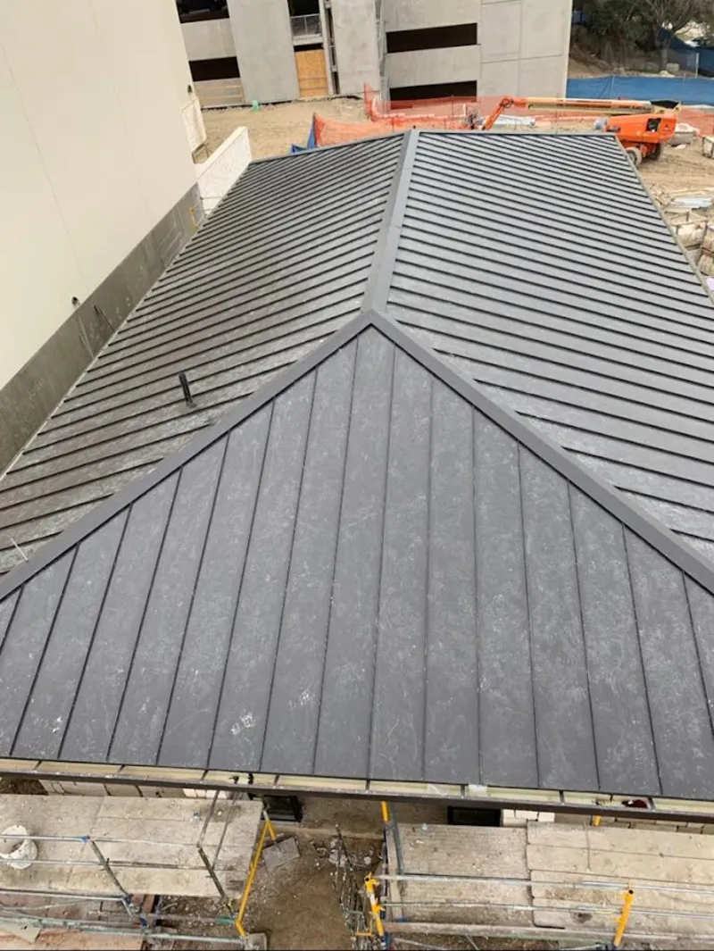 Commercial metal roof construction with crane equipment in Bernalillo